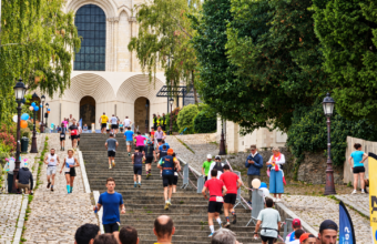 Coureurs gravissant les marches de la montée Saint-Maurice devant la cathédrale d’Angers lors d’une course solidaire pour le Téléthon.